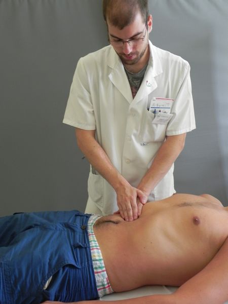 Figure presents peer tutor performing clinical examination of the abdomen